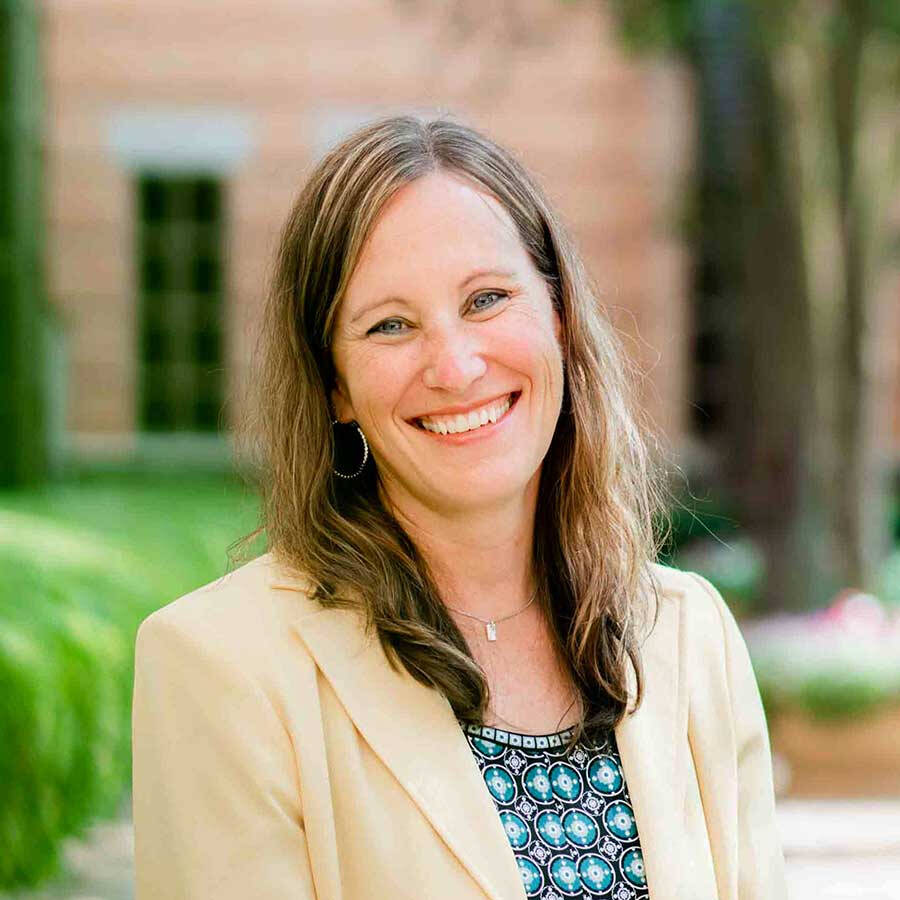 Dr. Hamilton at the Pew City campus wearing a beige suit jacket and a print top